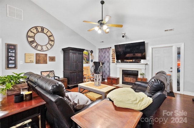 living room featuring ceiling fan, high vaulted ceiling, wood-type flooring, and a tile fireplace