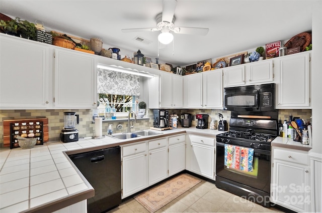 kitchen featuring white cabinetry, black appliances, light tile patterned floors, tile counters, and ceiling fan