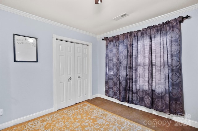 unfurnished bedroom featuring ceiling fan, a closet, and ornamental molding