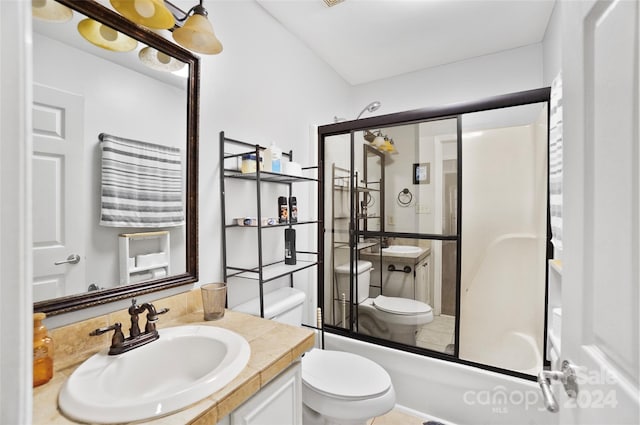 full bathroom featuring tile patterned flooring, shower / bath combination with glass door, toilet, and vanity