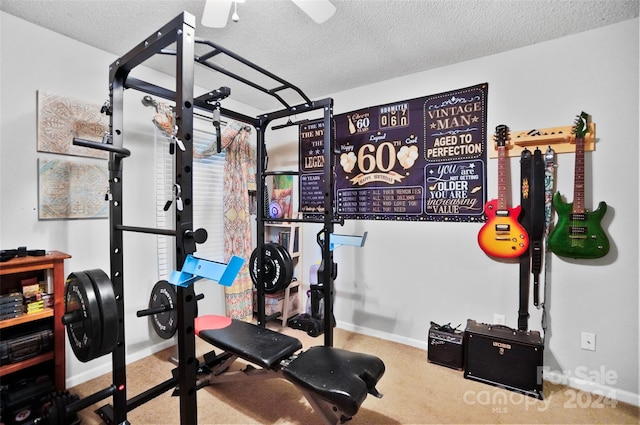 exercise room featuring a textured ceiling and carpet floors