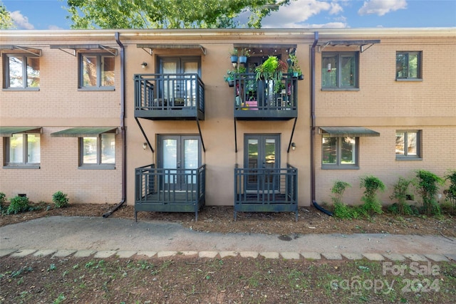 townhome / multi-family property with a balcony and french doors