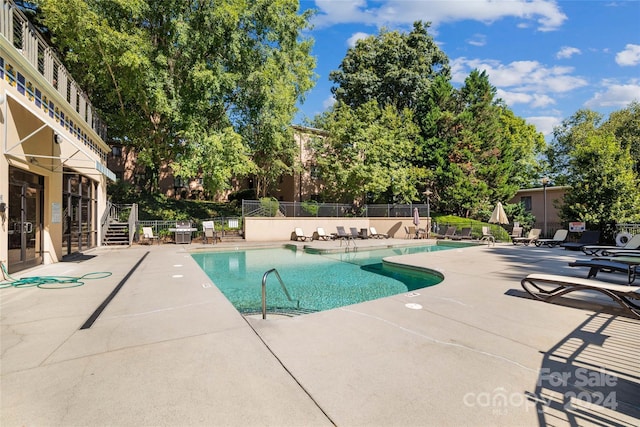 pool featuring fence and a patio