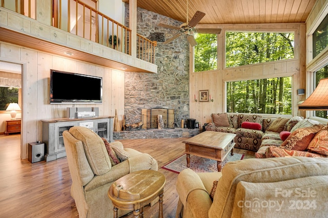 living room featuring light wood-type flooring, a fireplace, high vaulted ceiling, ceiling fan, and wooden ceiling