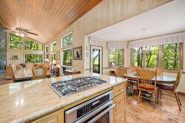 kitchen with light hardwood / wood-style flooring, light brown cabinetry, ceiling fan with notable chandelier, stainless steel appliances, and lofted ceiling