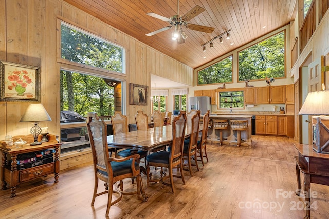 dining space with wooden ceiling, rail lighting, and high vaulted ceiling