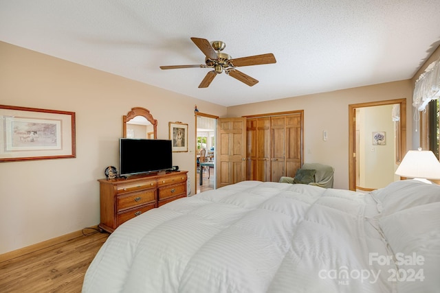 bedroom with a closet, ceiling fan, multiple windows, and light wood-type flooring