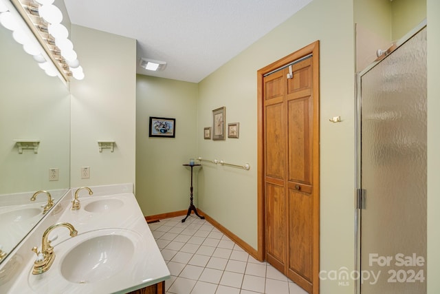 bathroom with tile patterned floors, a textured ceiling, and dual bowl vanity