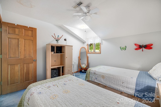 carpeted bedroom with ceiling fan, vaulted ceiling, and a textured ceiling