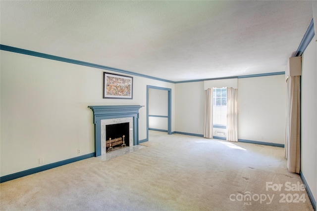 unfurnished living room with light colored carpet, a fireplace, a textured ceiling, and ornamental molding