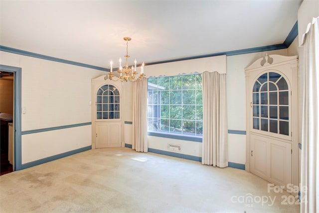 unfurnished dining area featuring a chandelier, ornamental molding, and light carpet