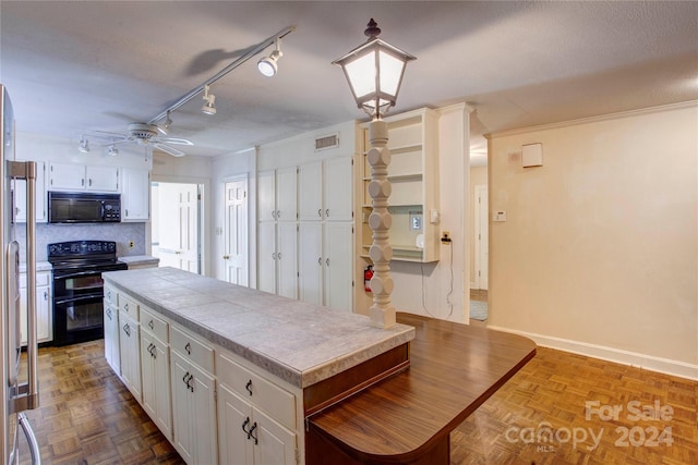 kitchen featuring parquet flooring, white cabinets, track lighting, stove, and ceiling fan