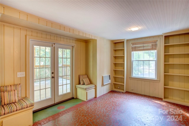 doorway featuring built in features, wooden walls, and french doors