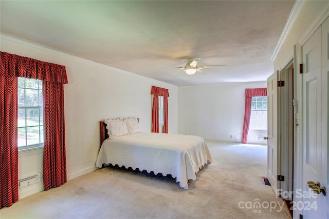 carpeted bedroom featuring ceiling fan and crown molding