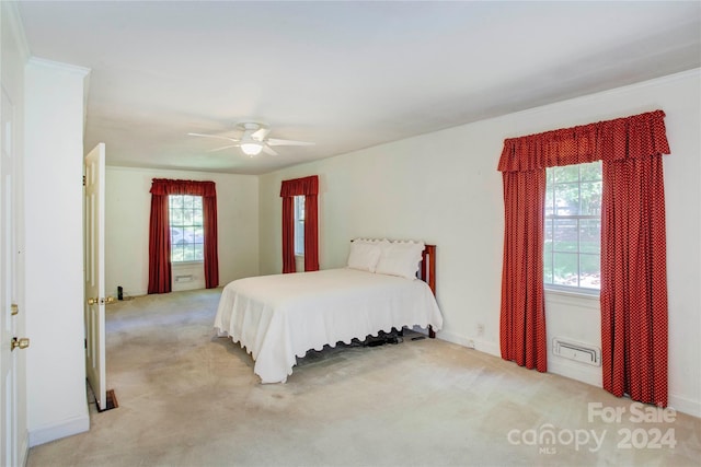 carpeted bedroom with ceiling fan and multiple windows