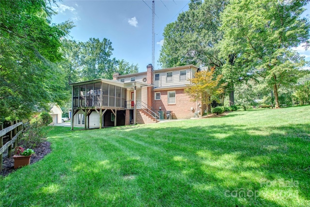 back of house featuring a lawn and a sunroom