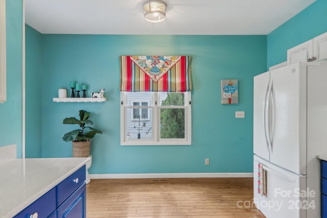 23 Country Meadows Ln, Hendersonville, NC 28792 - kitchen with baseboards, blue cabinets, wood-type flooring, and freestanding refrigerator