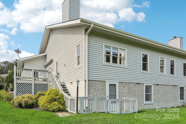 23 Country Meadows Ln, Hendersonville, NC 28792 - view of home's exterior with stairway, a deck, a lawn, and a chimney
