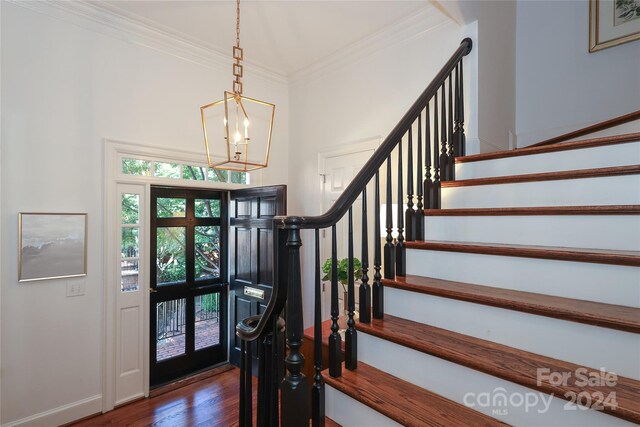 entryway with dark hardwood / wood-style floors and crown molding