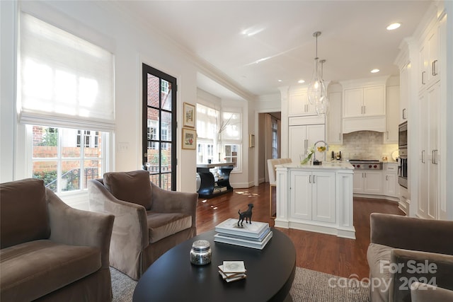 living room with dark hardwood / wood-style flooring and crown molding