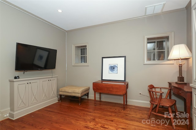 sitting room featuring ornamental molding and hardwood / wood-style flooring