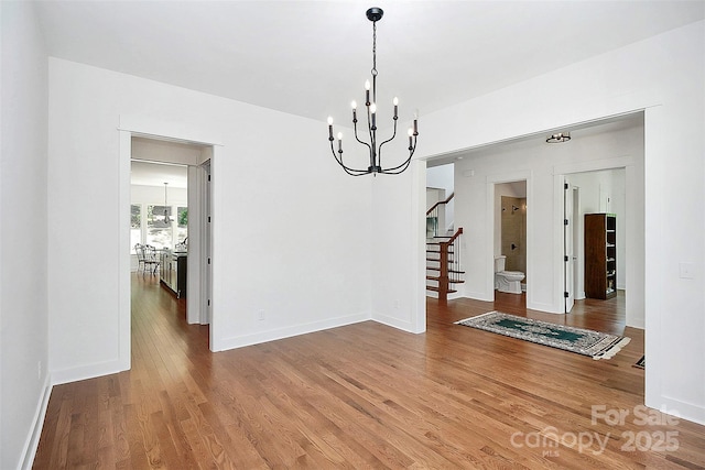 unfurnished dining area featuring hardwood / wood-style floors and a notable chandelier