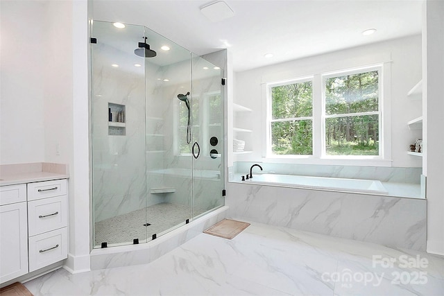 bathroom with vanity and shower with separate bathtub