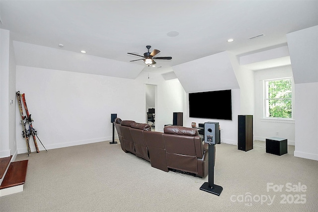 home theater room featuring vaulted ceiling, light carpet, and ceiling fan