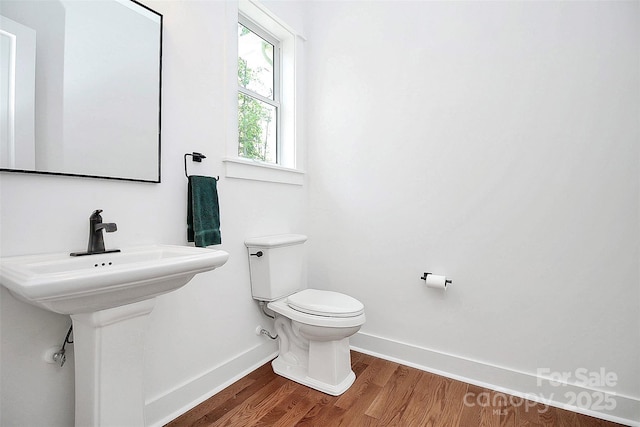 bathroom with toilet and hardwood / wood-style floors