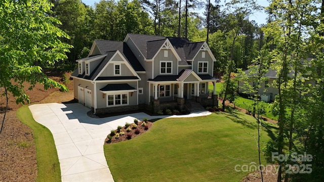 view of front of house with a garage, a front yard, and a porch