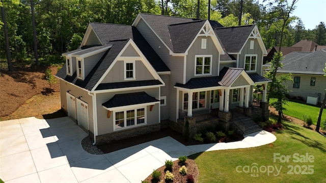 craftsman inspired home with a porch, a garage, and a front lawn