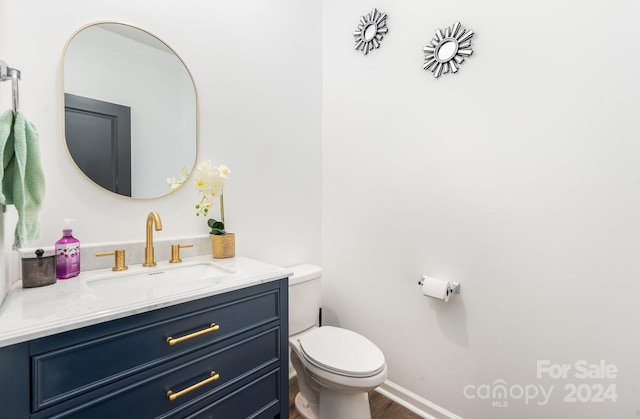 bathroom featuring hardwood / wood-style flooring, toilet, and vanity