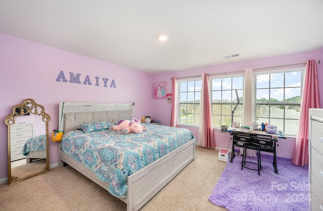 bedroom with multiple windows and light carpet