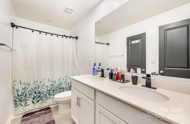 bathroom featuring dual bowl vanity and toilet