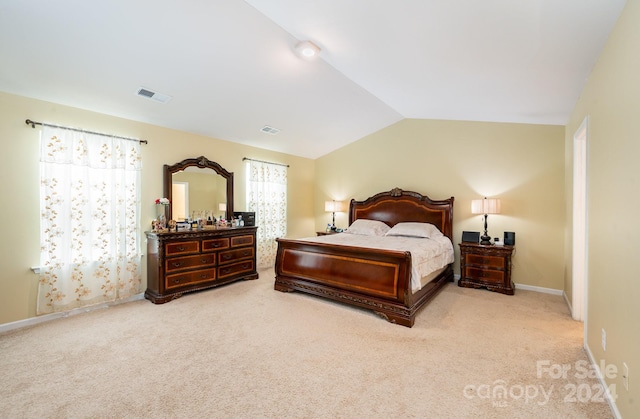 bedroom with vaulted ceiling and light colored carpet