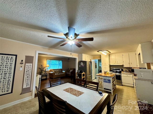 tiled dining space with a textured ceiling and ceiling fan