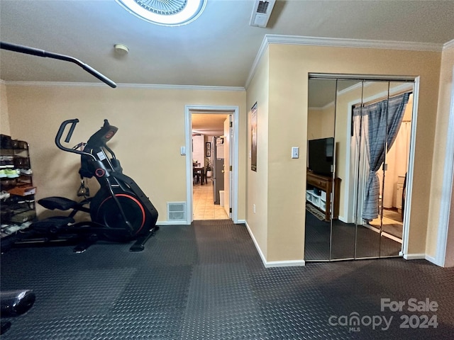 exercise room with crown molding and carpet