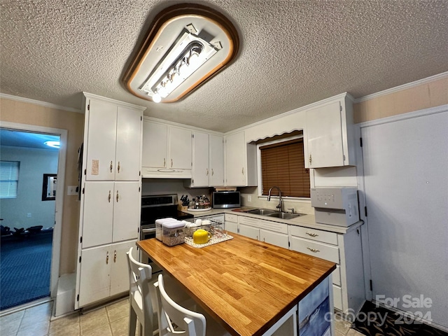 kitchen featuring a textured ceiling, crown molding, sink, and white cabinetry