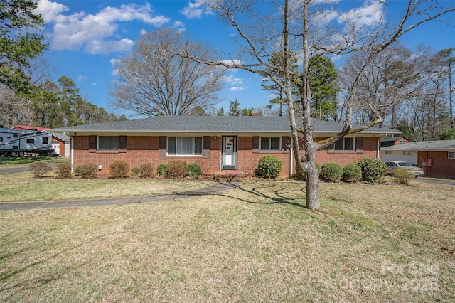 ranch-style home featuring a front lawn, brick siding, and a chimney