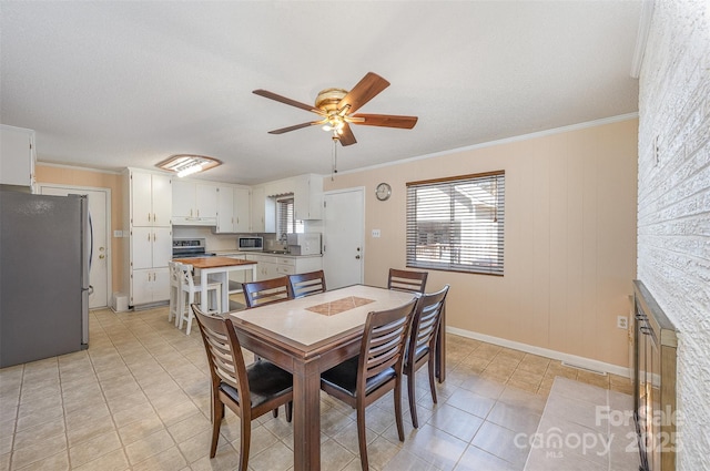 dining room featuring light tile patterned floors, a ceiling fan, baseboards, visible vents, and ornamental molding