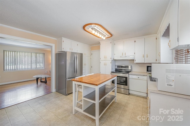 kitchen with wooden counters, crown molding, under cabinet range hood, appliances with stainless steel finishes, and white cabinets