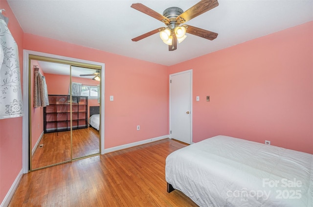 bedroom featuring a closet, baseboards, a ceiling fan, and hardwood / wood-style flooring