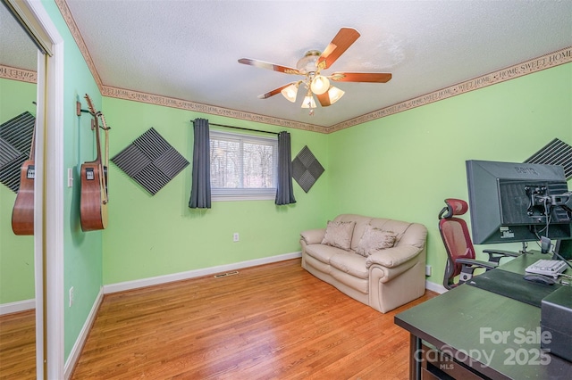 home office featuring baseboards, a textured ceiling, and wood finished floors