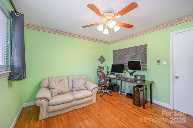 office space with ceiling fan, baseboards, and wood finished floors