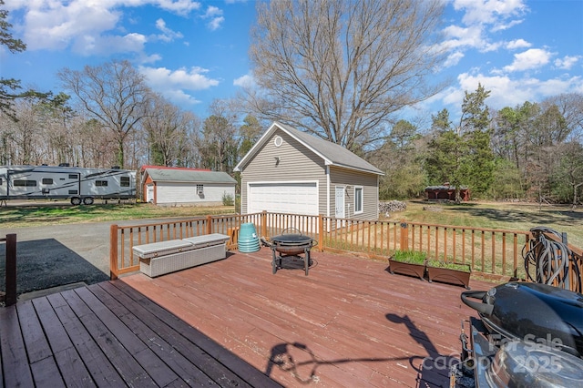 wooden deck featuring a garage, area for grilling, and an outdoor structure