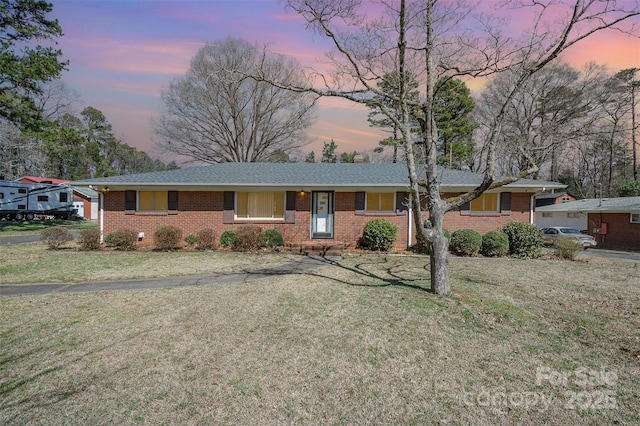 single story home featuring brick siding and a front lawn