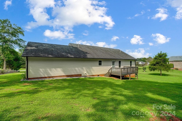 back of property with a deck and a yard