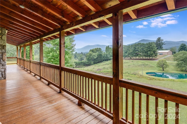 deck with a mountain view and a yard