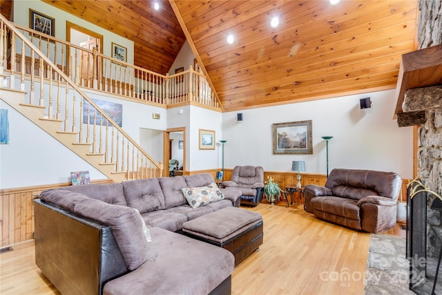 living room featuring light wood-type flooring, high vaulted ceiling, a high end fireplace, and wood ceiling