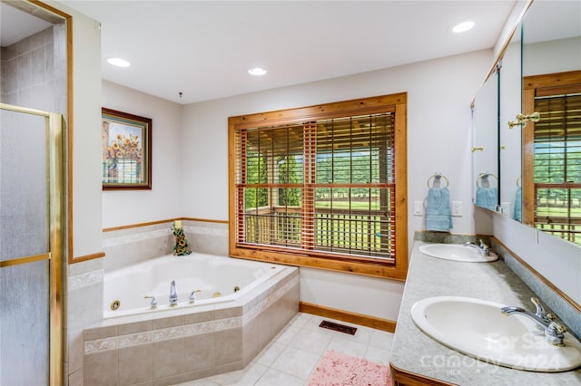 bathroom featuring a wealth of natural light, plus walk in shower, double vanity, and tile patterned flooring